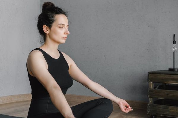 Person practicing a calm, focused movement in a minimalist room.